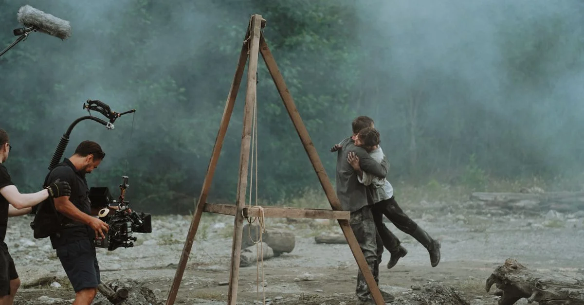 Étreinte cinématographique capturée sur un plateau de tournage en plein air dans la fumée.
